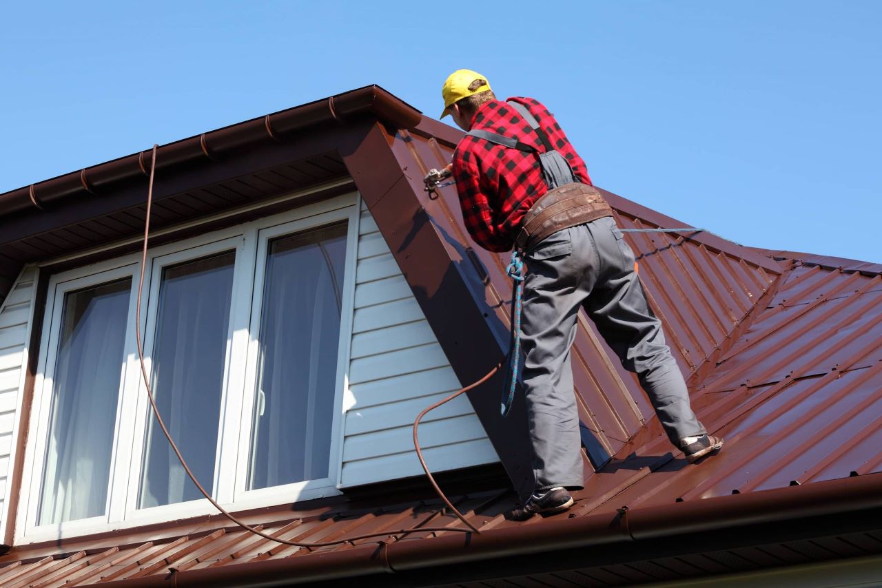 Man Painting The Roof With BrownPaint