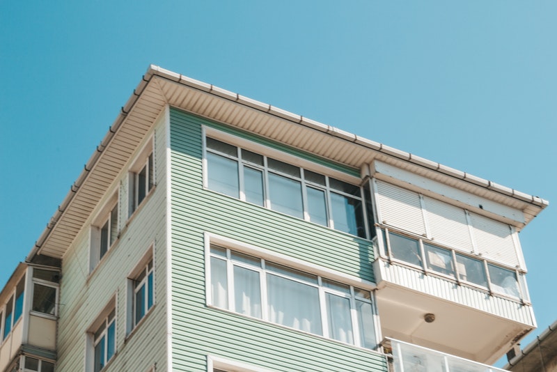 Three-storey green house with gutter and windows