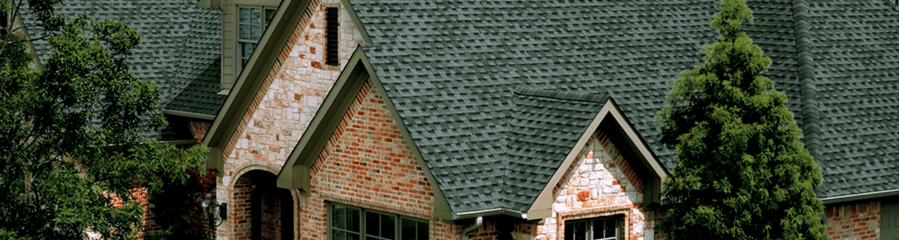 Big Residential House with Green Bricks Roofing and Trees On the Right and Left side