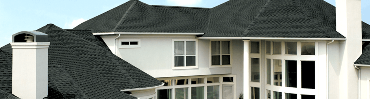 Big Commercial Property with Dark Gray Roofing, Chimney on the Left Side and Glass Windows