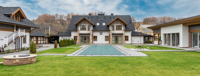 A big two-storey residential house with grey roof and white color walls