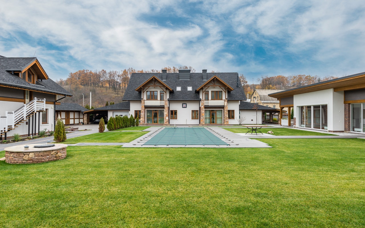 A big two-storey residential house with grey roof and white color walls